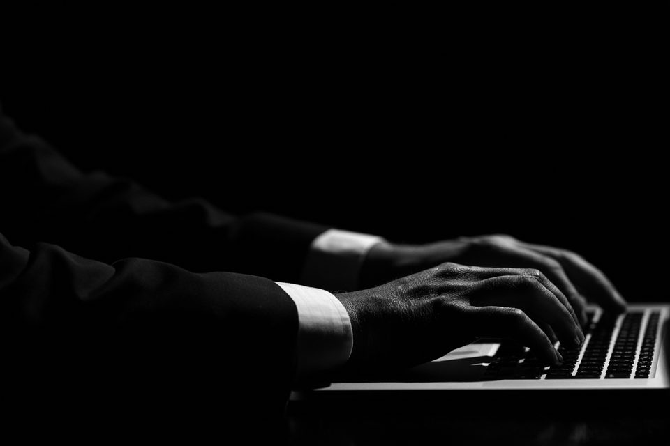 Hands working at a laptop.